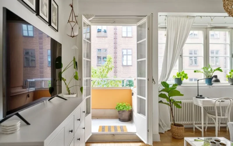Cozy Scandinavian-style living room with a sunlit balcony and modern decor.