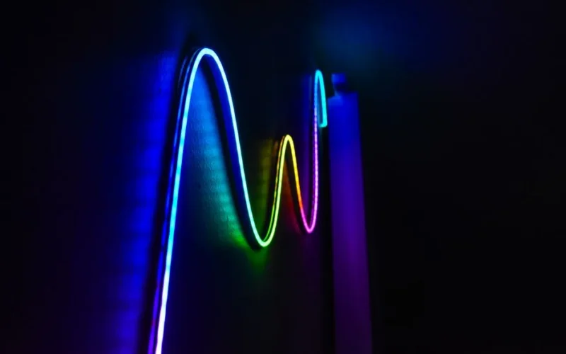 Colorful neon wave pattern LED lights illuminating a dark room for a modern home decor aesthetic.