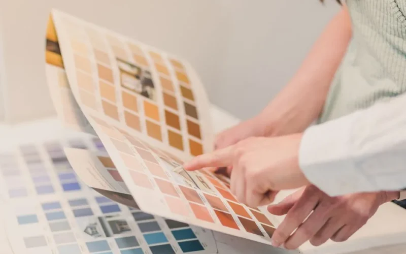 Two people discussing and choosing color palettes for interior design projects.
