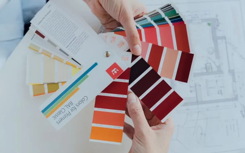 Person choosing color palettes for interior design projects, emphasizing creative choices.