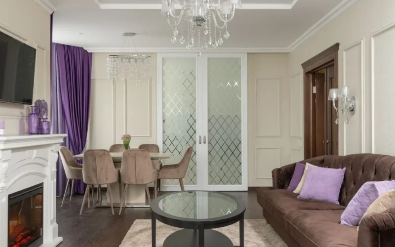 Stylish living room interior featuring a chandelier, fireplace, and purple accents.