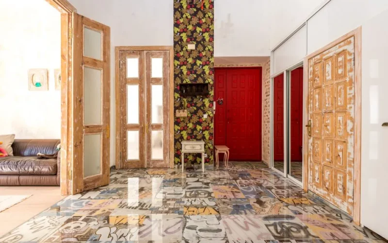 Vibrant and eclectic interior featuring floral wall, graffiti floor, and rustic wood doors.
