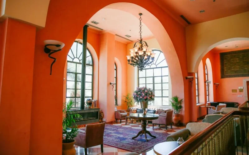 Bright living room interior with Mediterranean design, arch windows, and floral decor.