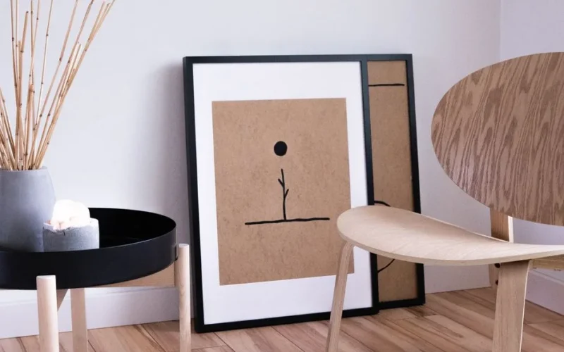 A serene Japandi style room with minimalist wooden furniture and abstract art on display.