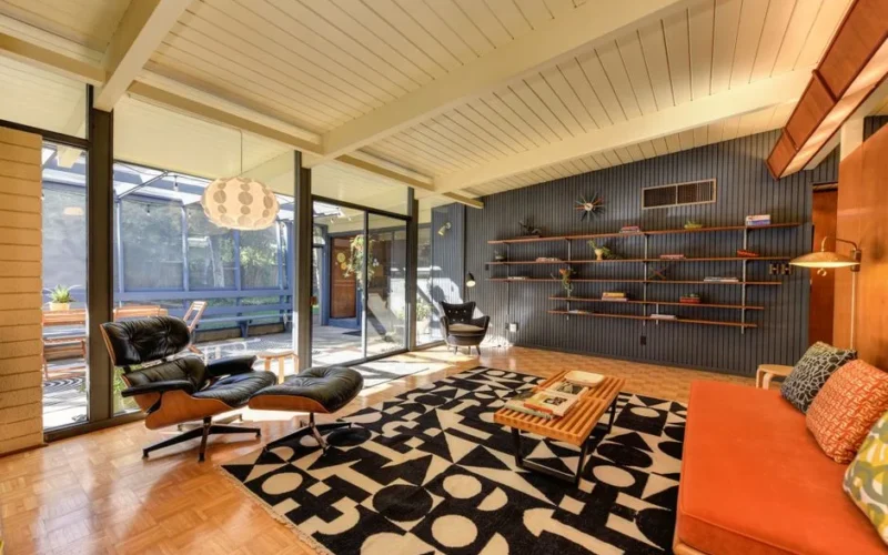 Stylish mid-century modern living room with armchairs, shelves, and natural light.