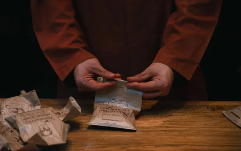 A barista carefully folds coffee bags at an artisan coffee shop, creating an authentic and warm atmosphere.