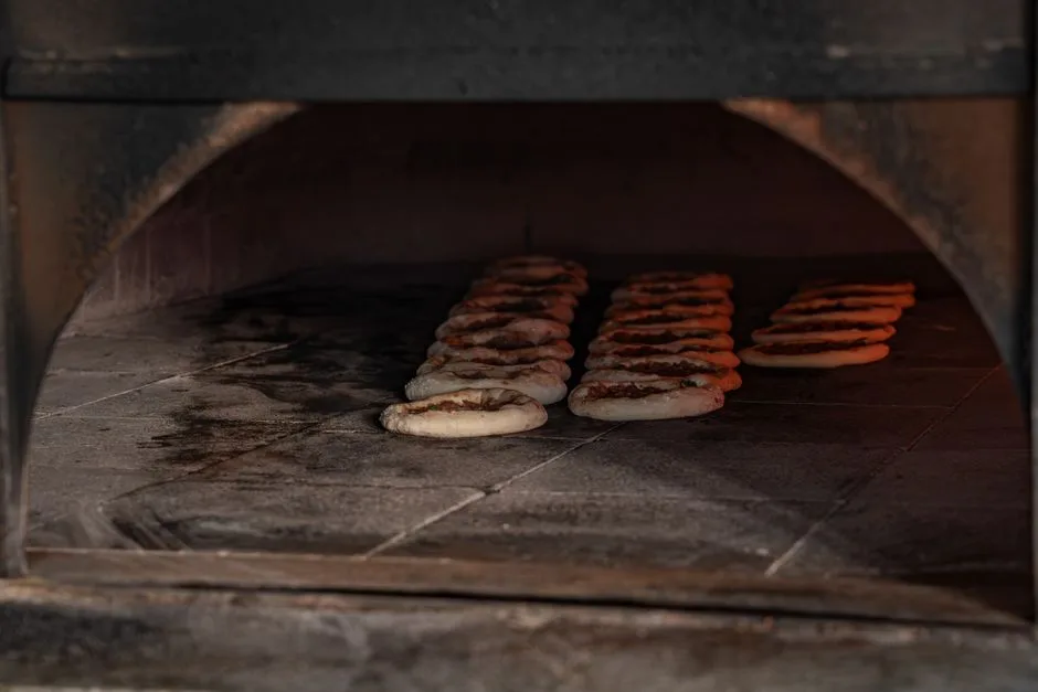 Delicious flatbreads baking inside a rustic stone oven showcase traditional culinary methods.