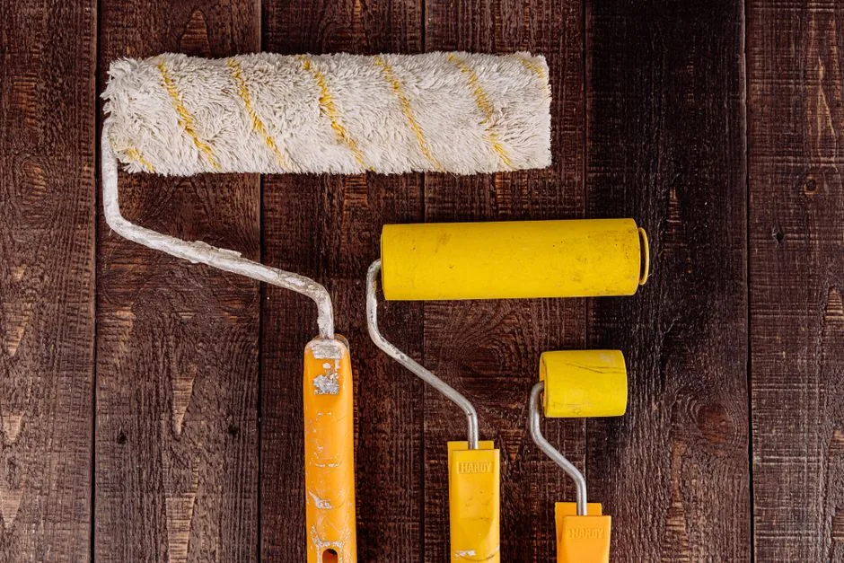 Top view of yellow paint rollers arranged on a wooden background, perfect for DIY and home improvement projects.
