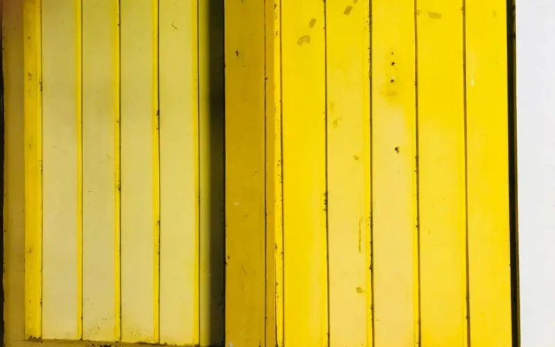 Textured yellow wooden door panels create a bold and vibrant look, perfect for design inspiration.