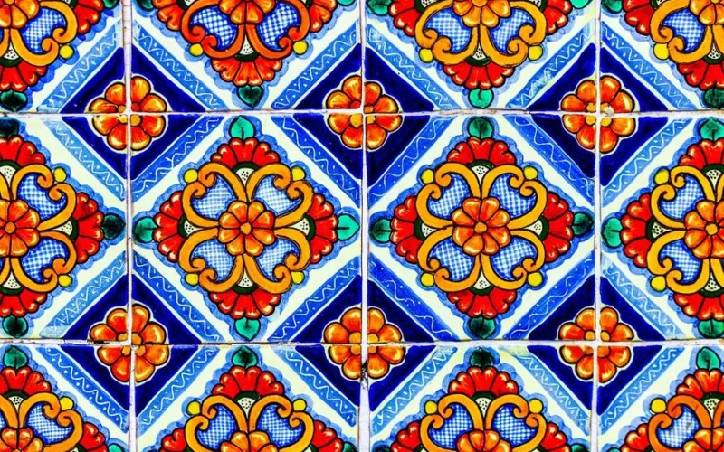 Colorful traditional Mexican Talavera ceramic tile with painted tin glazed floral pattern as abstract background
