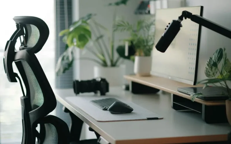 Stylish home office setup with ergonomic chair, plants, and tech accessories creating a modern work environment.