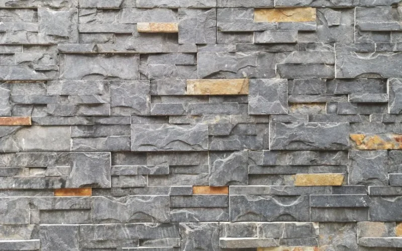 A close-up of a textured stone wall made of slate and granite bricks for architectural design.