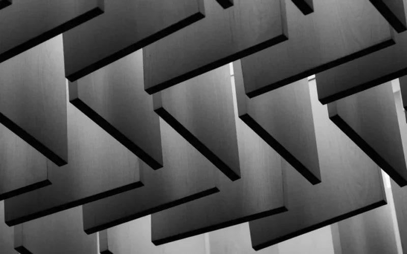 Abstract view of geometric wooden panels arranged on a ceiling, creating a modern architectural design.