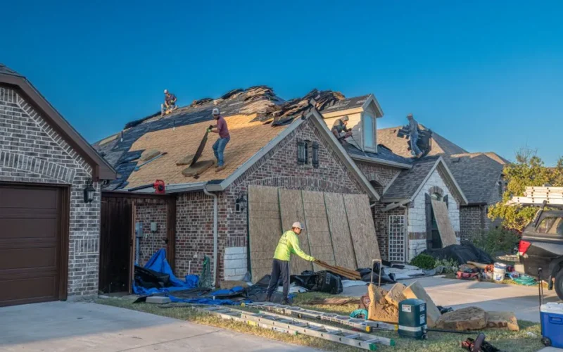 Workers engage in roof replacement on a brick house in Fort Worth, Texas.