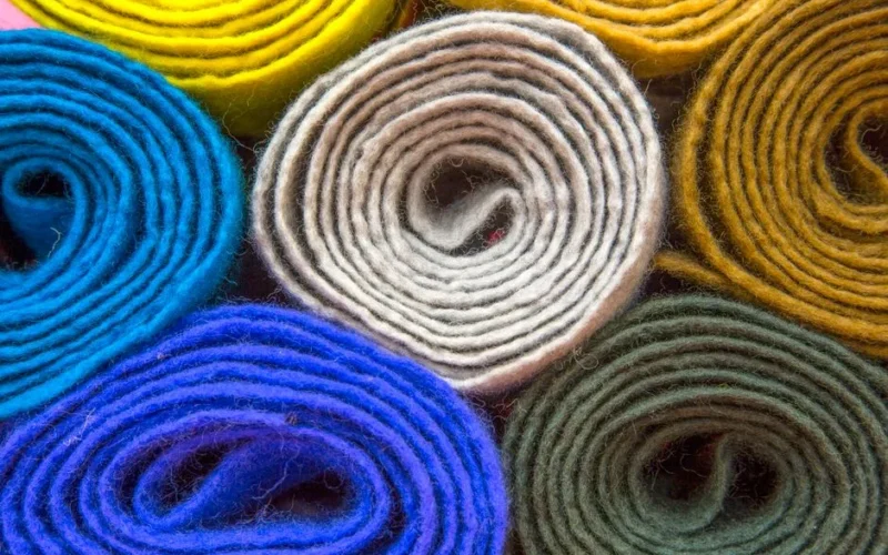 Vibrant rolled felt fabrics in various colors, showcasing textile diversity and texture.