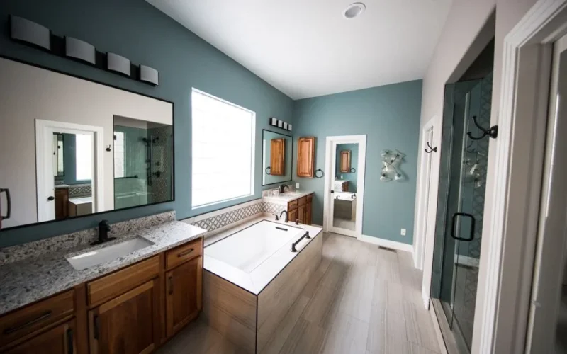 Spacious modern bathroom featuring a freestanding bathtub, wooden cabinets, and granite countertops.