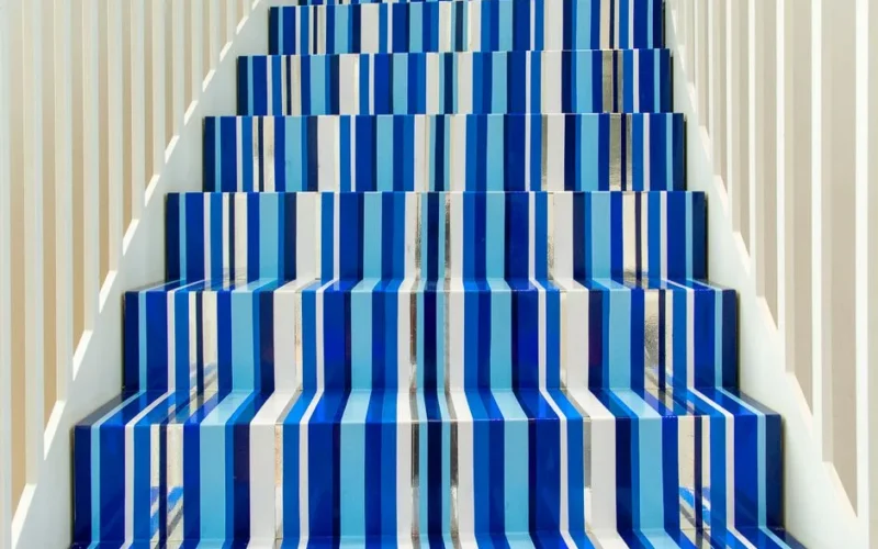 Bold blue and white striped staircase inside a bright modern setting.