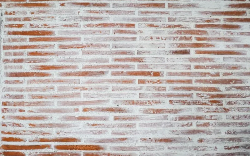 Textured red brick wall with white mortar, perfect for backgrounds and designs.