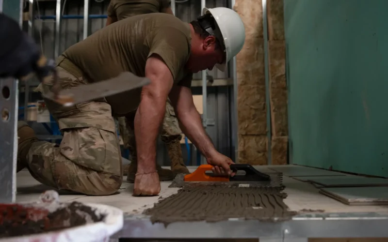 U.S. Air Force Tech. Sgt. Armando Robles, water and fuels systems craftsman assigned to the 156th Civil Engineer Squadron, Puerto Rico Air National Guard, applies tiles grout during a Deployment for Training (DFT) at Aviano Air Base, Italy, June 24, 2025. During the DFT, the 156th CES developed their skill proficiency in a new area of responsibility while supporting real-world projects that support the U.S. European Command operations. (U.S. Air National Guard photo by Senior Airman Victoria Jewett)