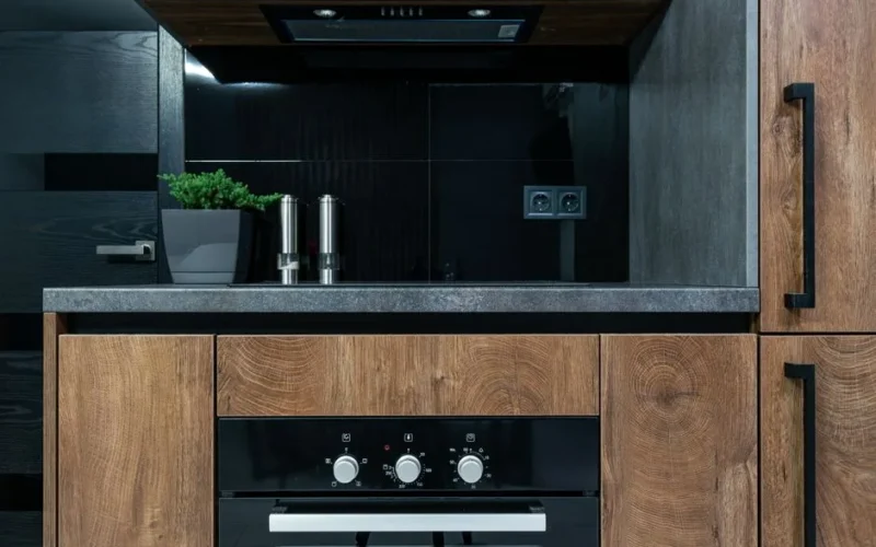 Stylish kitchen interior featuring wooden cabinets, black accents, and modern appliances.