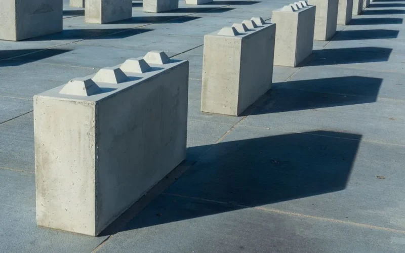Artistically arranged concrete blocks casting shadows on the ground.