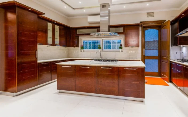 Modern kitchen with dark wood cabinets and marble countertops, emphasizing elegant interior design.