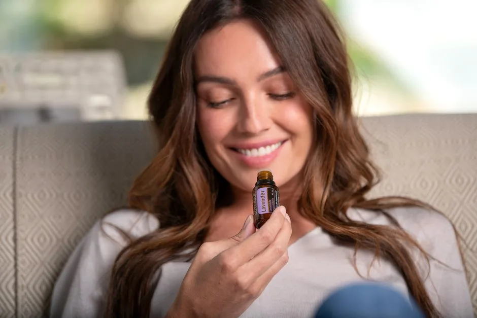 A woman enjoying the aroma of lavender essential oil, promoting relaxation and natural therapy.